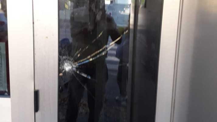 Il foro provocato nel vetro antisfondamento della sede della Camera del lavoro in via dei Martiri