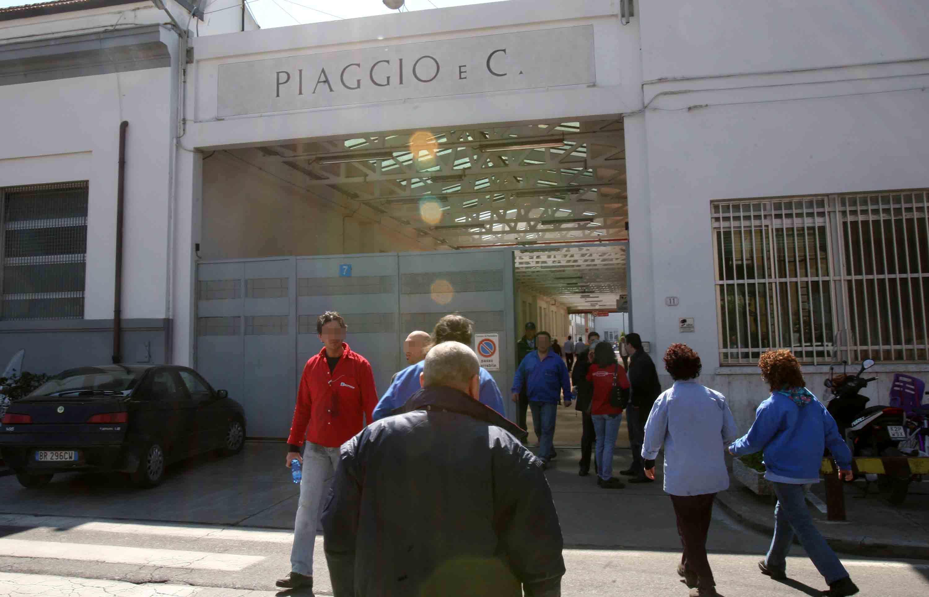 Operai di fronte all'ingresso della Piaggio di Pontedera