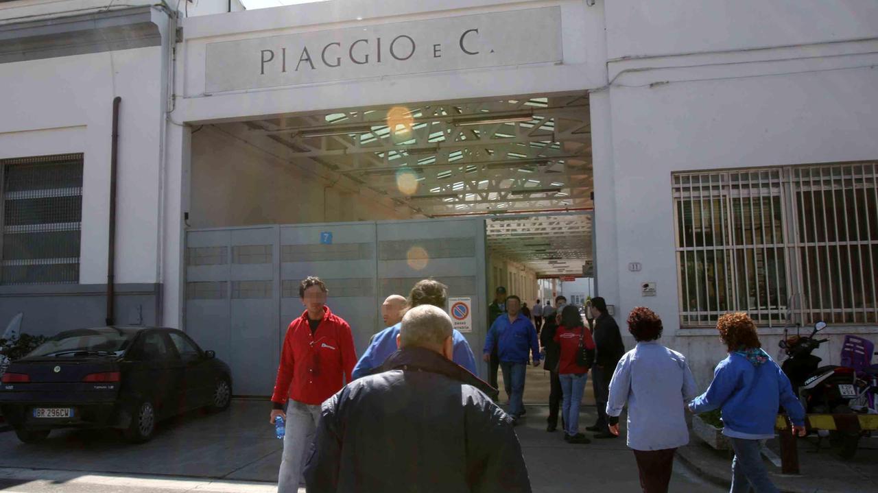 Operai di fronte all'ingresso della Piaggio di Pontedera