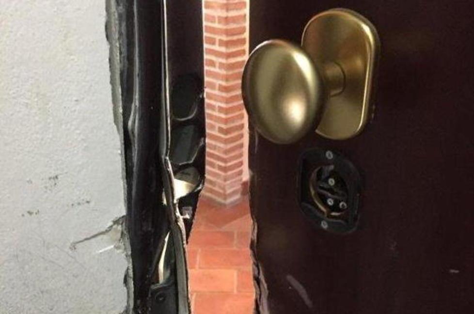 La porta blindata distrutta con un piede di porco