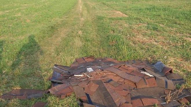 Coperture e lamiere abbandonate in un campo
