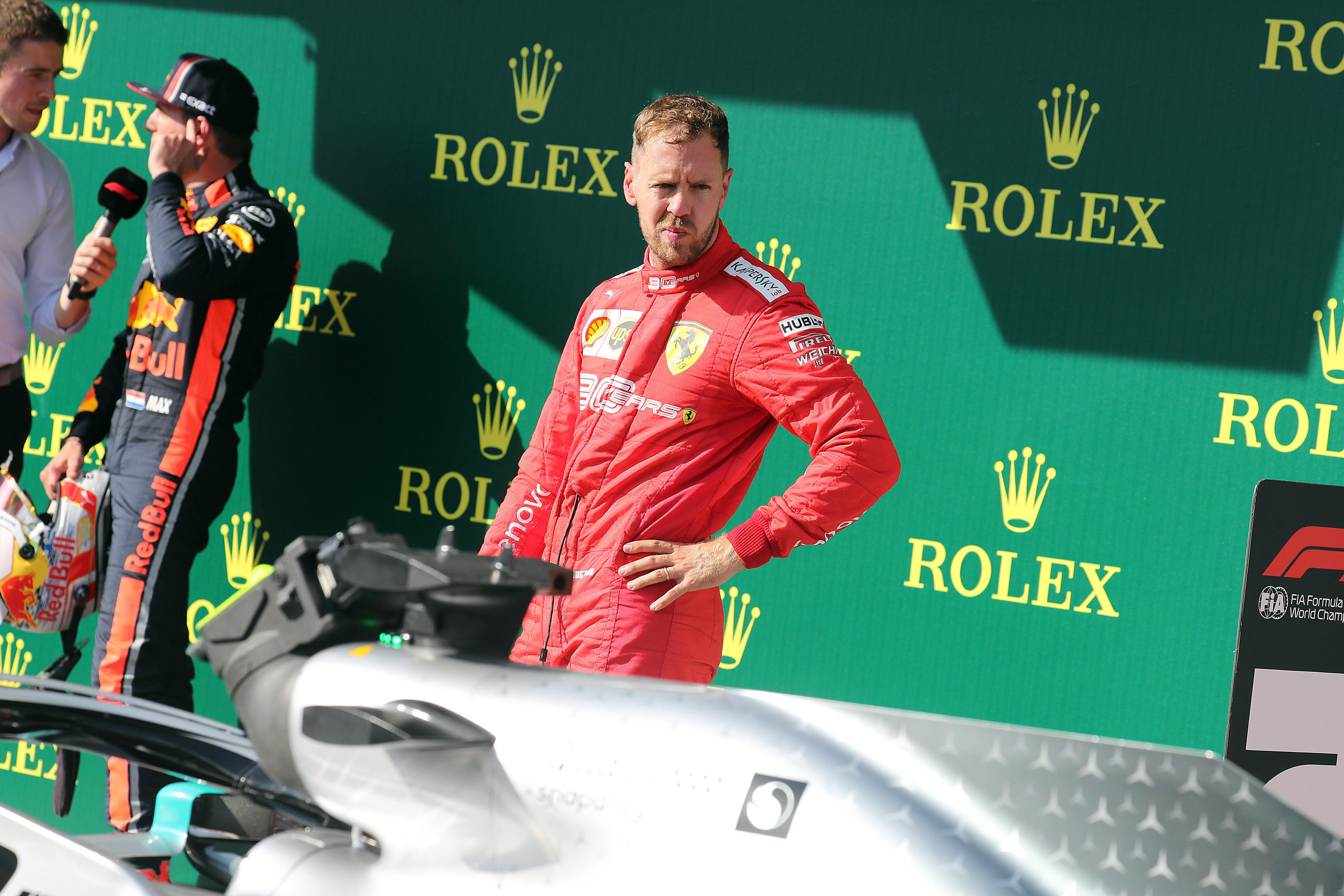 Sebastian Vettel guarda con aria di sconforto la Mercedes di Hamilton