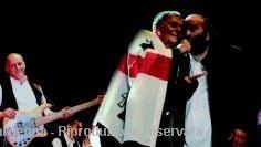 Roberto Vecchioni avvolto nella bandiera dei quattro mori durante un concerto con il gruppo nuorese degli Istentales: l&#146;amicizia si trasforma in un tour musicale 