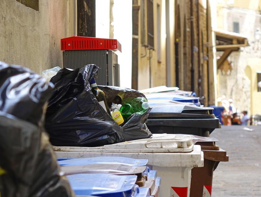 Rifiuti che si sono accumulati sui bidoni in una strada del centro storico (foto Lorenzo Gori)