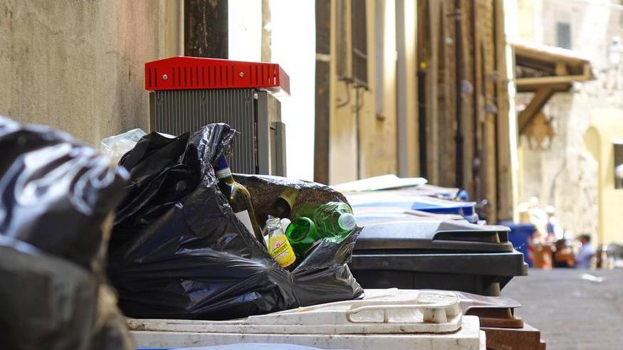 Rifiuti che si sono accumulati sui bidoni in una strada del centro storico (foto Lorenzo Gori)