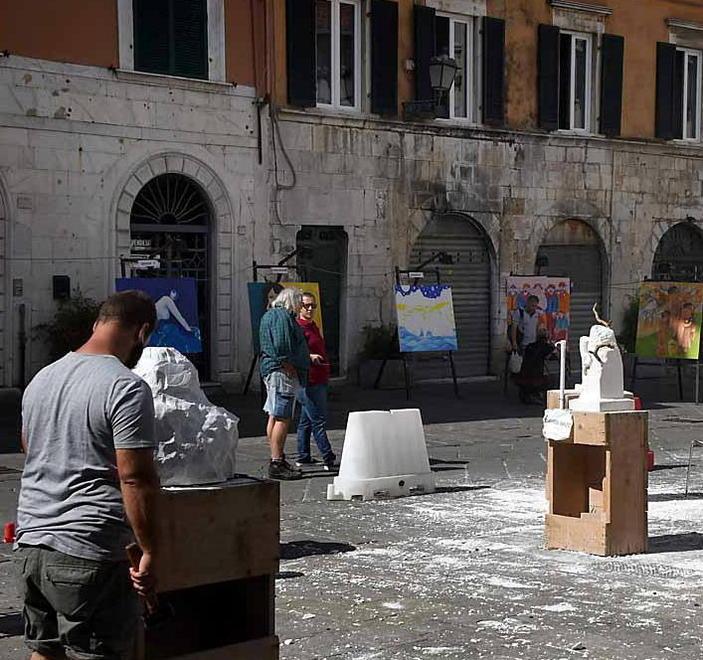 Lo scenario di piazza Duomo e gli artisti che scolpiscono