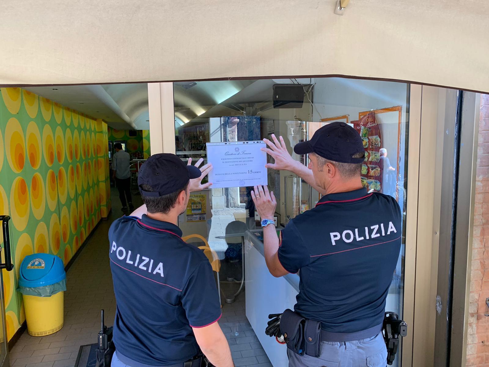Gli agenti di polizia amministrativa affiggono la notifica di chiusura all'ingresso del bar di via Mazzini