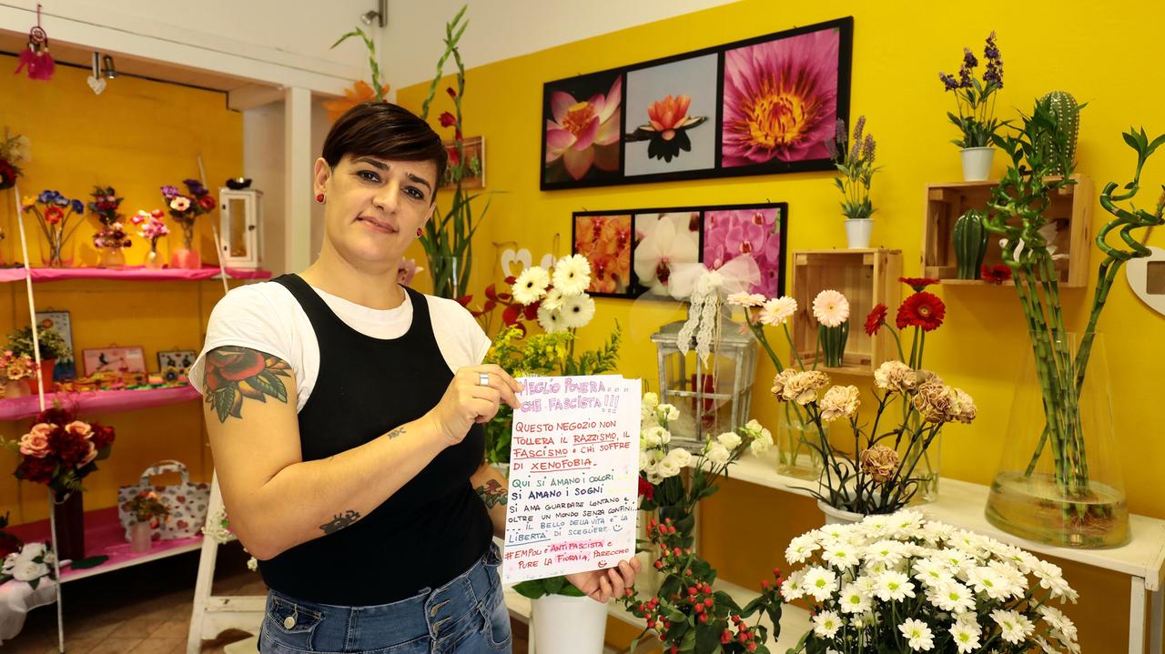 La fioraia Linda Bargellini mostra il "manifesto" antifascista e antirazzista (foto Sestini)