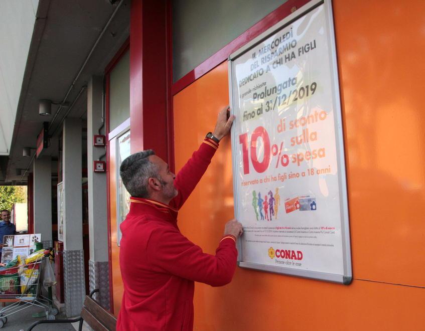 Uno dei dipendenti Conad al Campo d’aviazione davanti al cartello promozionale (foto Ciurca/Paglianti)