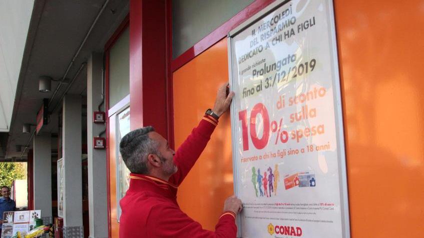 Uno dei dipendenti Conad al Campo d’aviazione davanti al cartello promozionale (foto Ciurca/Paglianti)