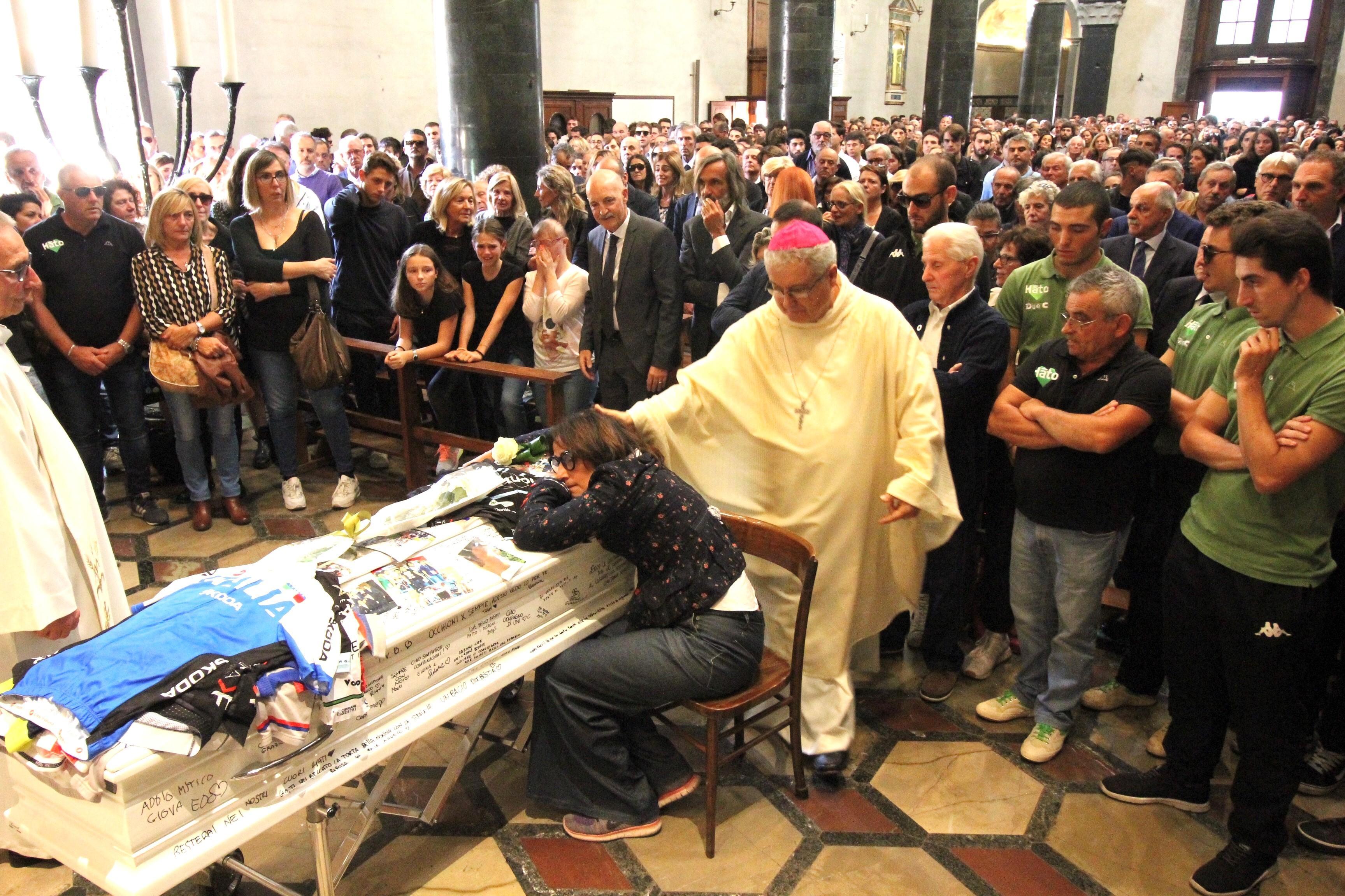La mamma di Giovanni Iannelli abbraccia la bara del figlio confortata dal vescovo Giovanni Nerbini (foto Batavia)