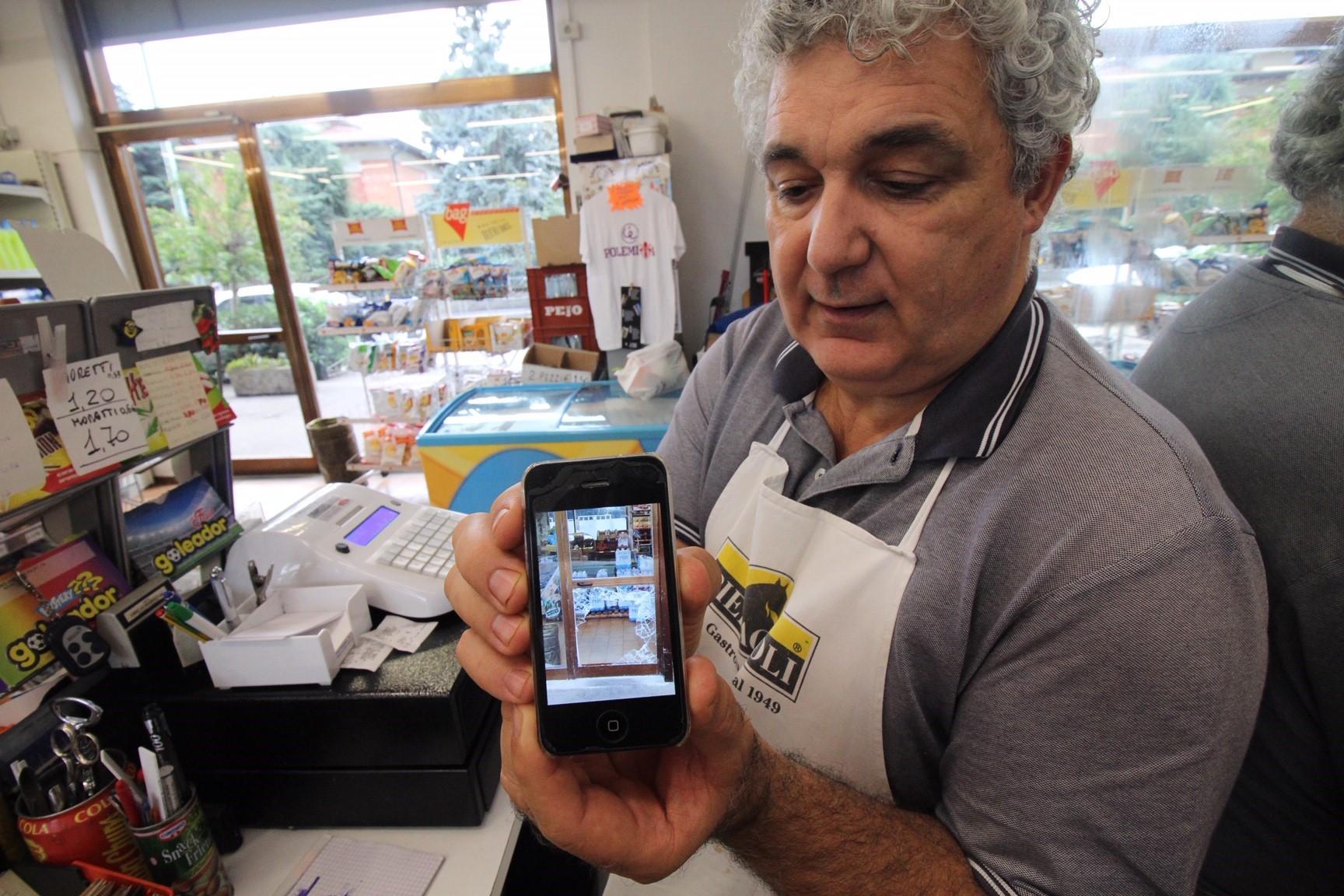 Riccardo Vannoni mostra il vetro infranto per compiere il furto nel negozio (foto Batavia)