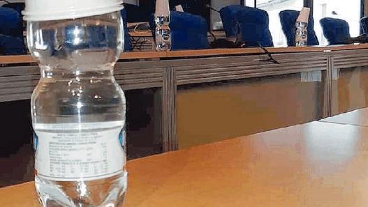 Sui banchi dei consiglieri comunali di Rosignano ci sono bottiglie e bicchieri di plastica
