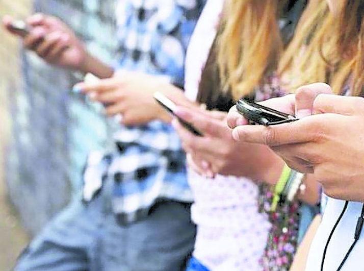 Ragazzini con i telefoni cellulari in mano