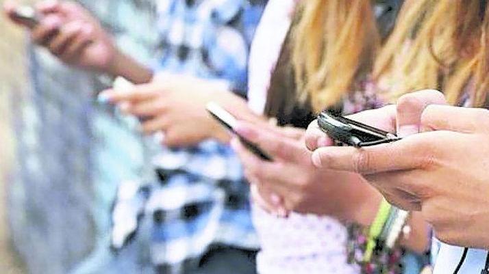 Ragazzini con i telefoni cellulari in mano