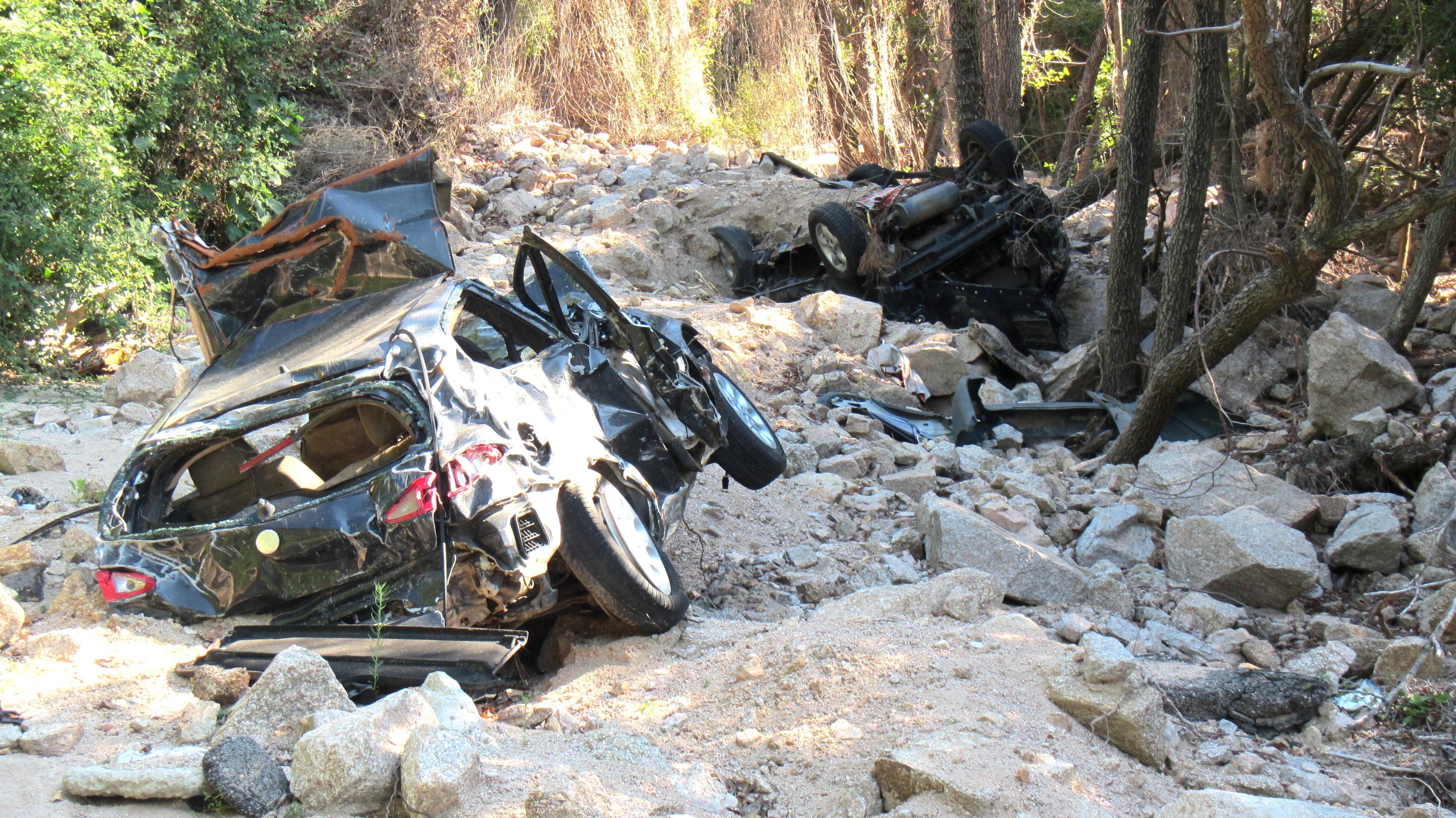 Le auto in fondo alla voragine. Ora sono state issate e depositate in un terreno vicino