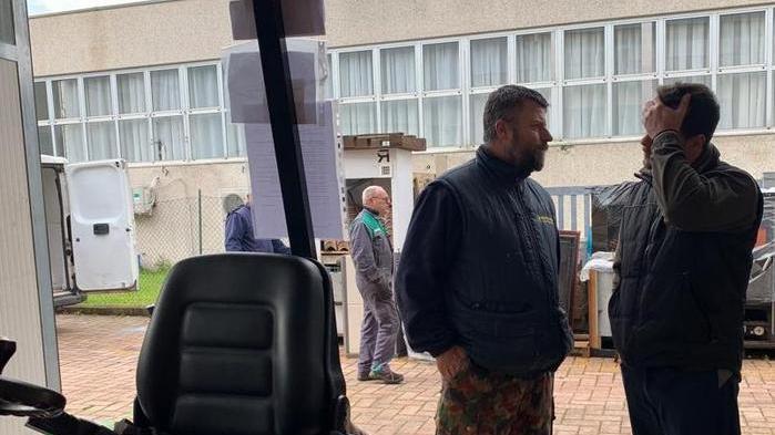 Il titolare (a destra) mentre parla con una persona all’esterno del negozio