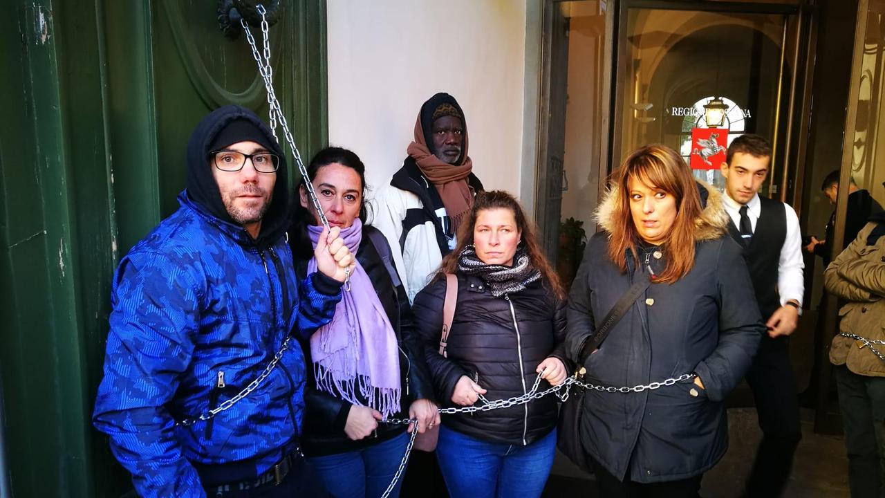 Alcuni ex operai incatenati di fronte alla sede della Regione a Firenze
