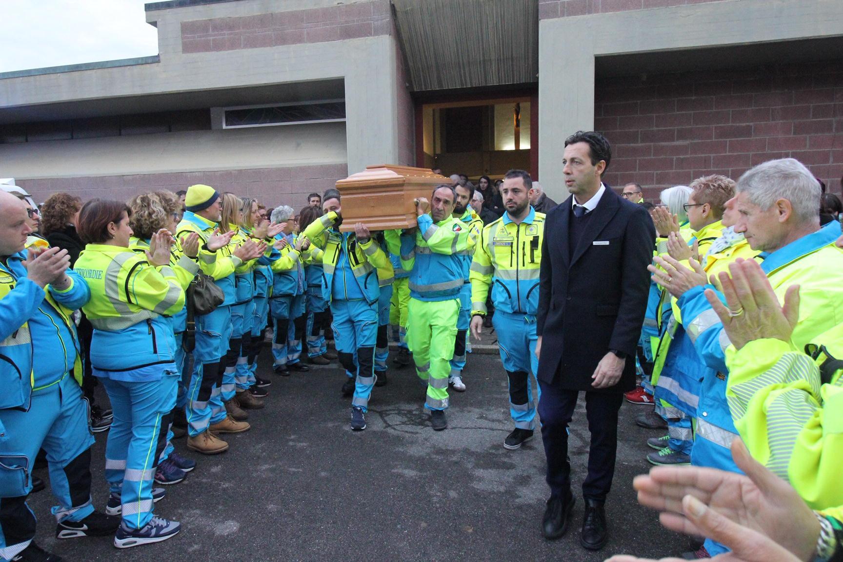Don Amidei coi volontari della Misericordia mentre escono dalla chiesa portando il feretro