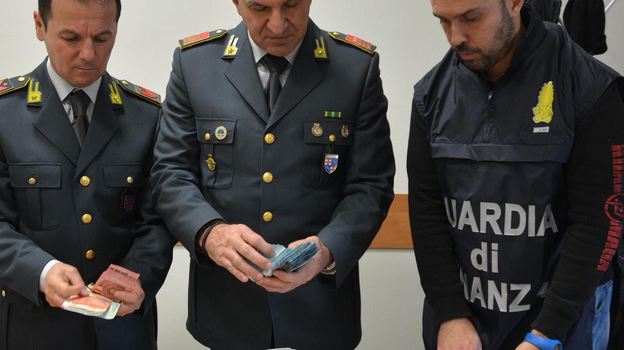 La Guardia di Finanza con il denaro sequestrato