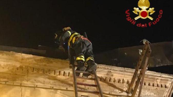 L'intervento di un vigile del fuoco in una palazzina danneggiata dal vento