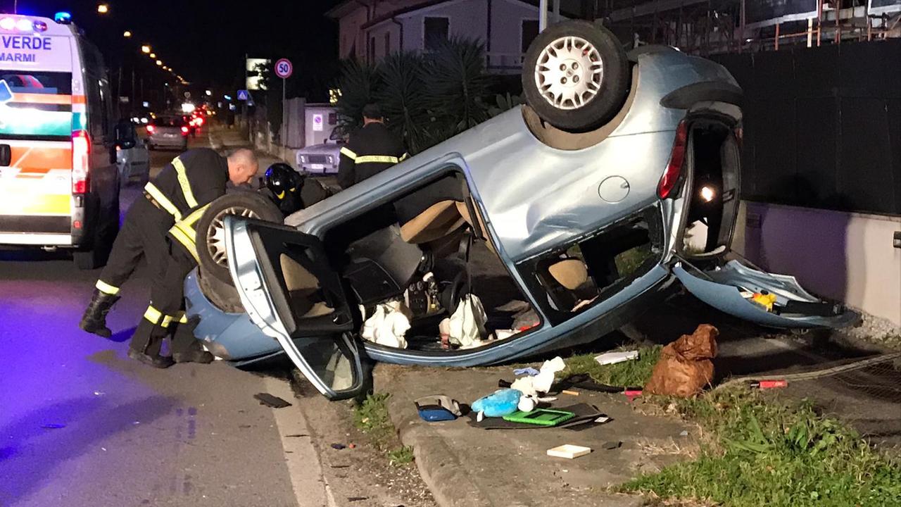 I vigili del fuoco al lavoro per rimuovere l'auto (foto Il Tirreno)
