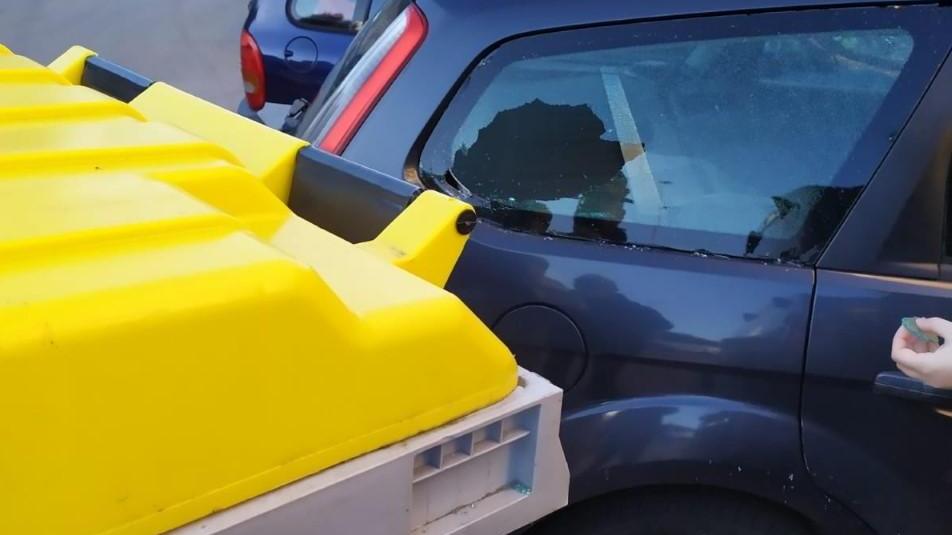 Cassonetto contro le auto in sosta