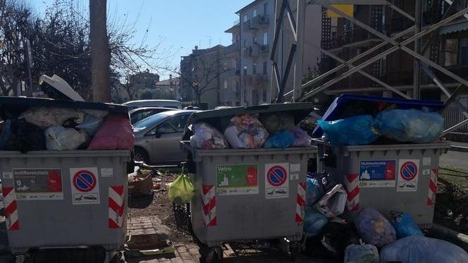 Cassonetti traboccanti di sacchetti e sporcizia