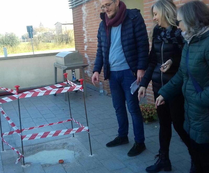 Davide Innocenti del Sunia insieme a due inquilini che osservano i pozzi neri che emanano cattivi odori
