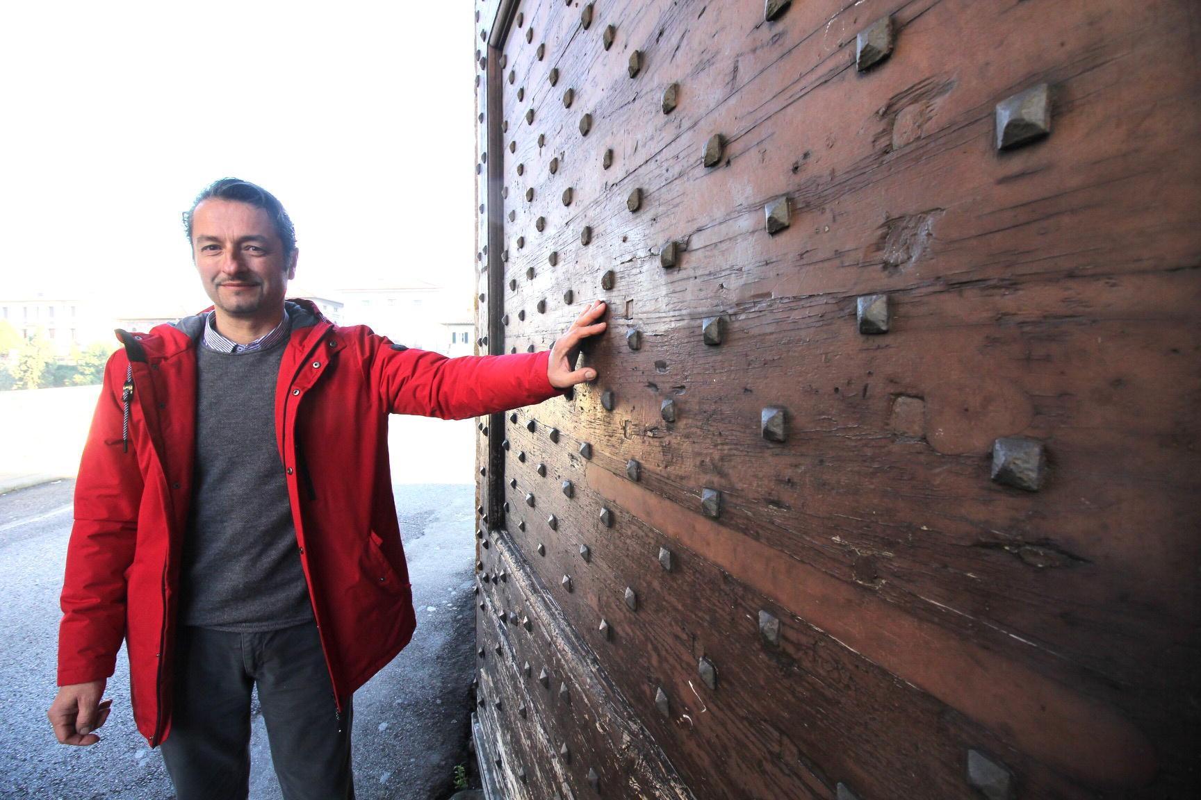 Paolo Bottari accanto ad una delle grandi ante della Porta Mercatale la cui ultima manutenzione seria risale a decine di anni fa (foto Batavia)