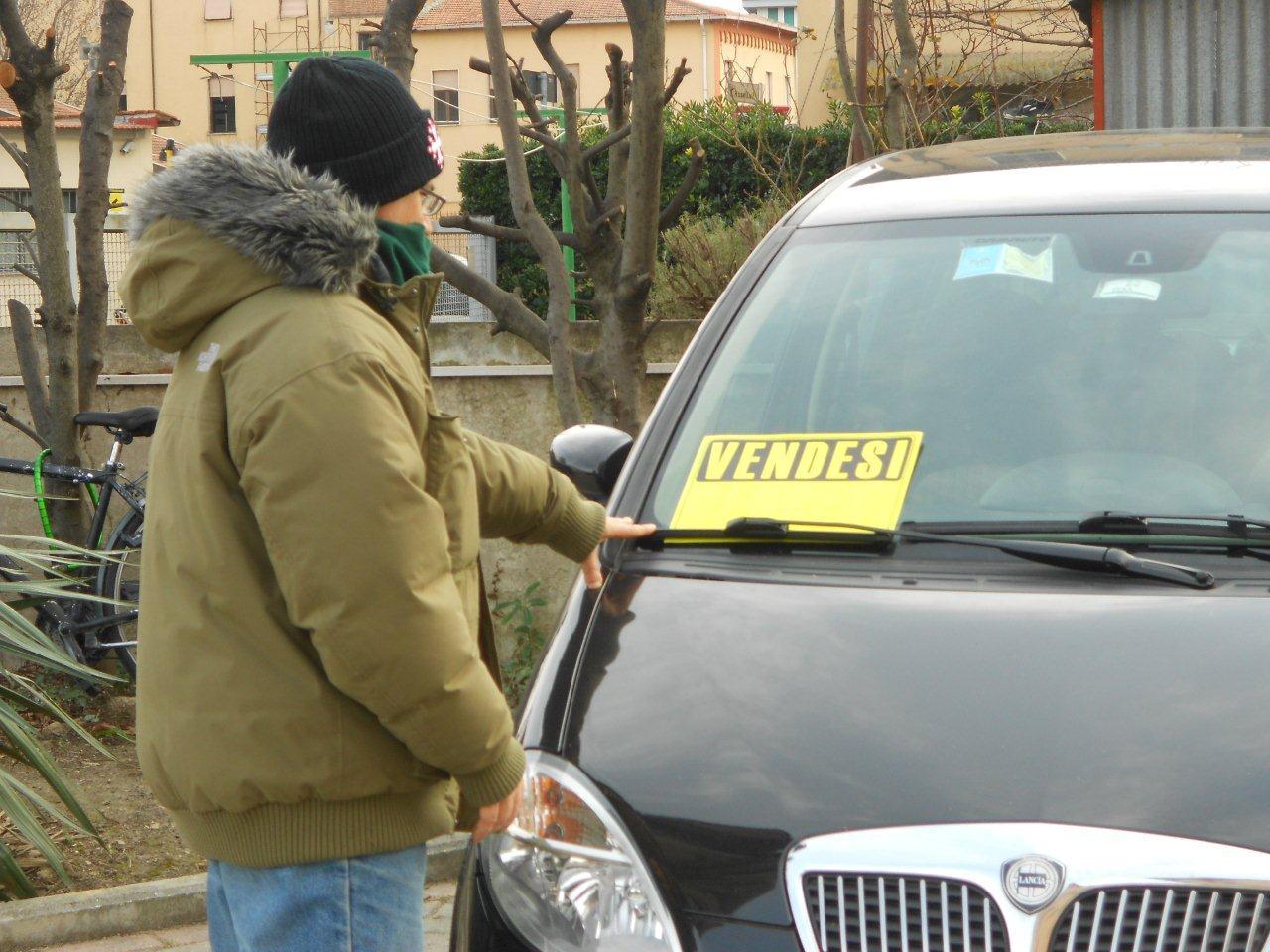 Un possibile acquirente in un salone di auto usate