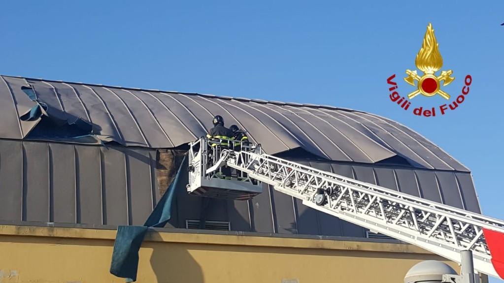 Un vigile del fuoco mette in sicurezza una tettoia danneggiata dal vento (foto Mario Rosas)