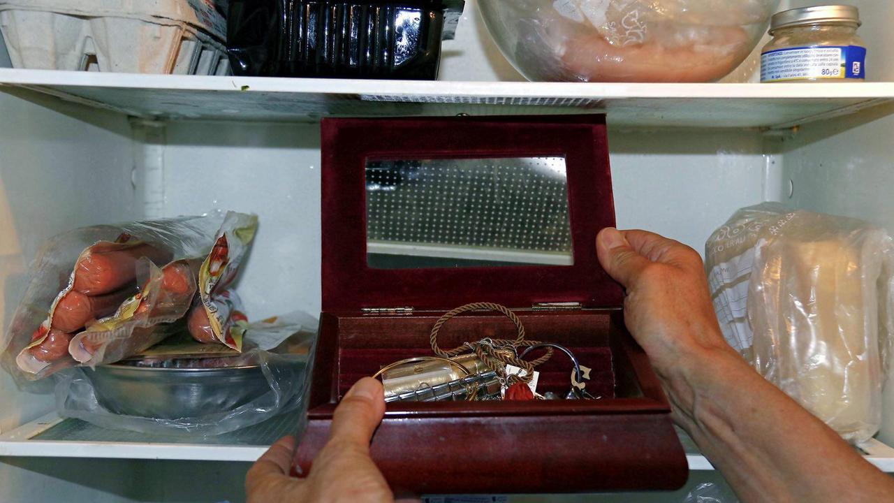 Una donna mette alcuni oggetti preziosi nel frigorifero (foto d'archivio)
