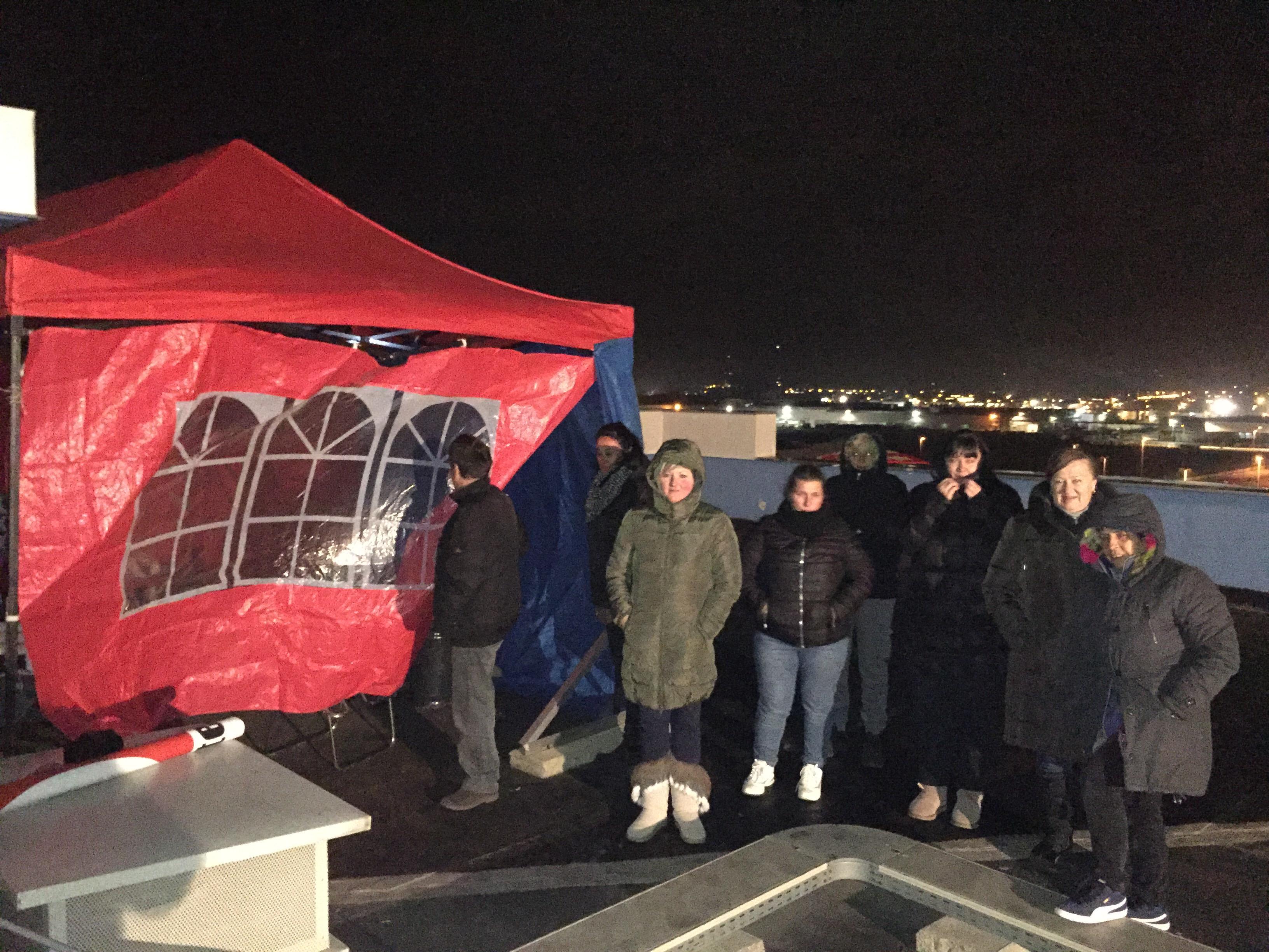 Un gruppo di operaie di notte sul tetto del Palazzo Blu