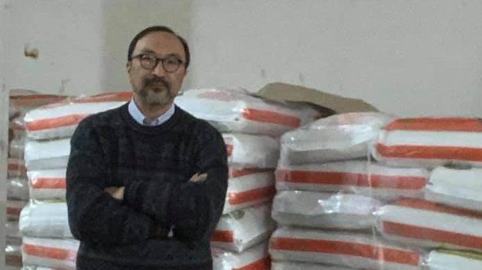 Il consigliere Marco Wong accanto ai sacchi di riso