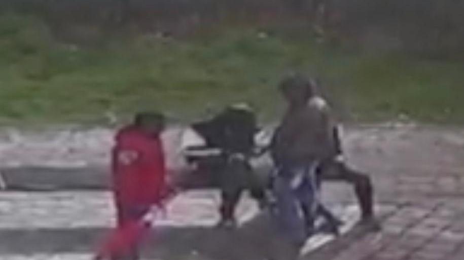 Le immagini riprese dalle telecamere di sorveglianza: due africani sono seduti su una panchina sotto la pensilina, un giovane arriva in bicicletta