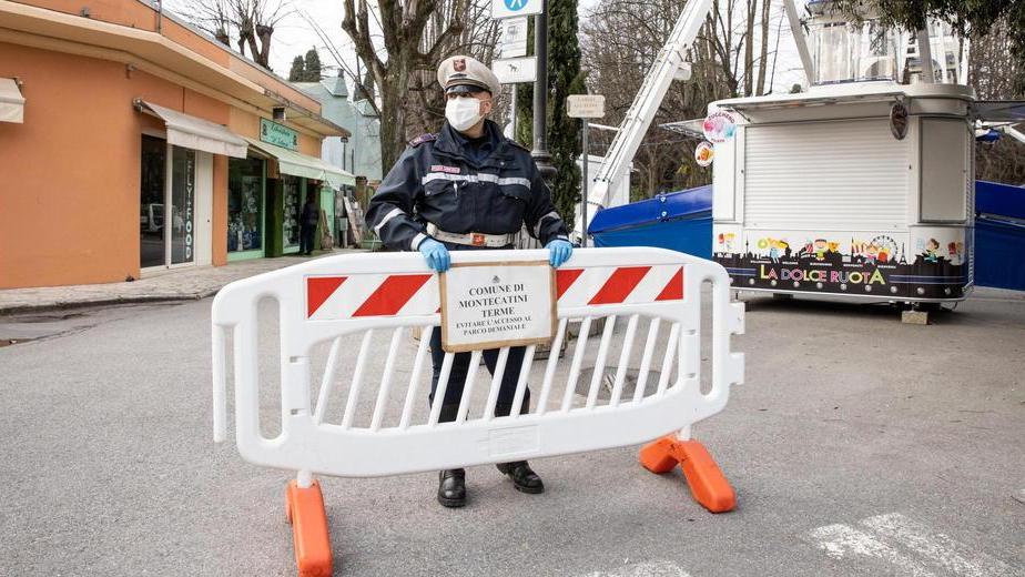 Un'agente della Polizia municipale piazza una transenna davanti a uno degli ingressi della pineta (Foto Nucci)