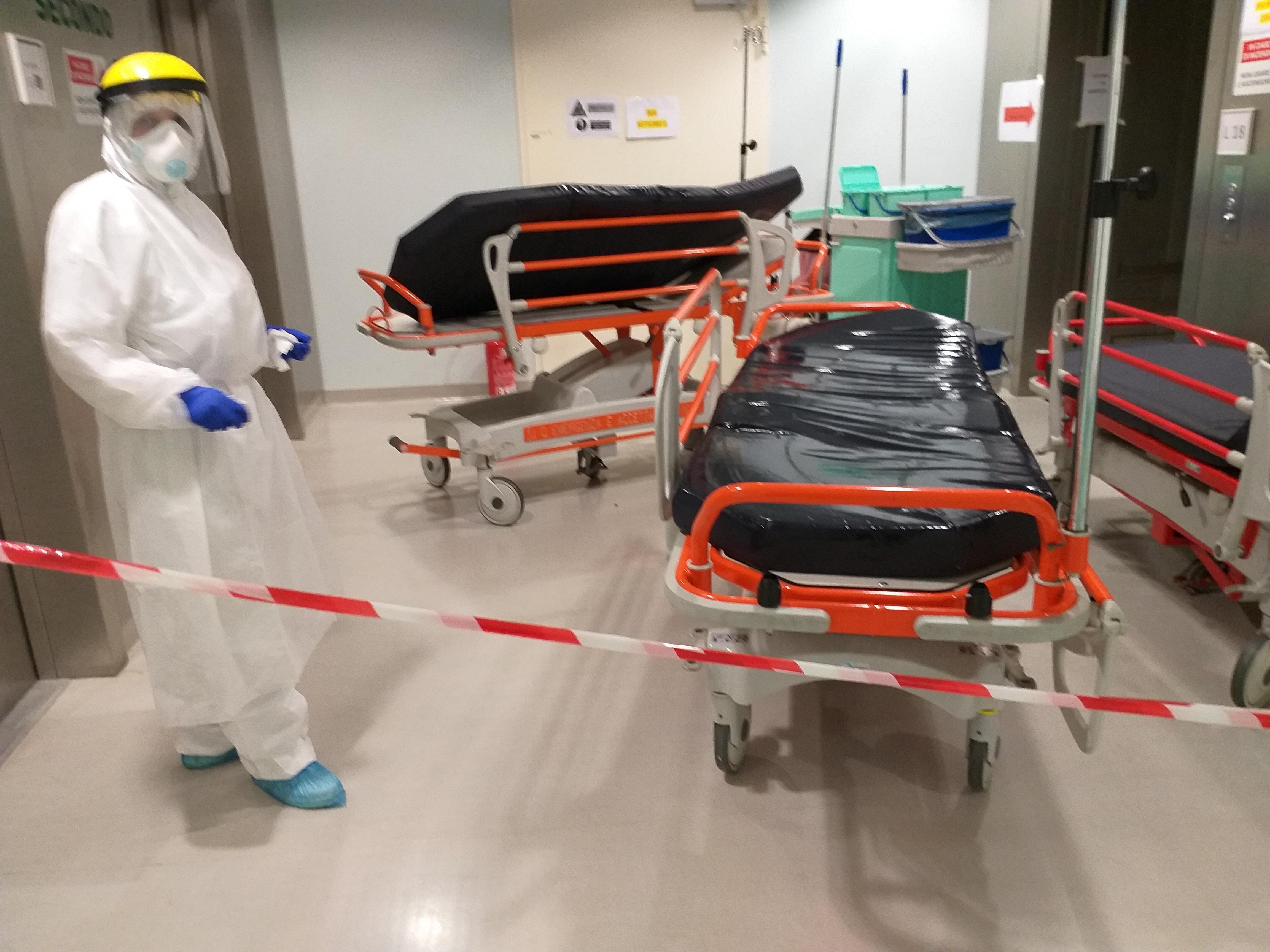 Un'operatrice socio-sanitaria disinfetta le barelle all'ospedale Santo Stefano