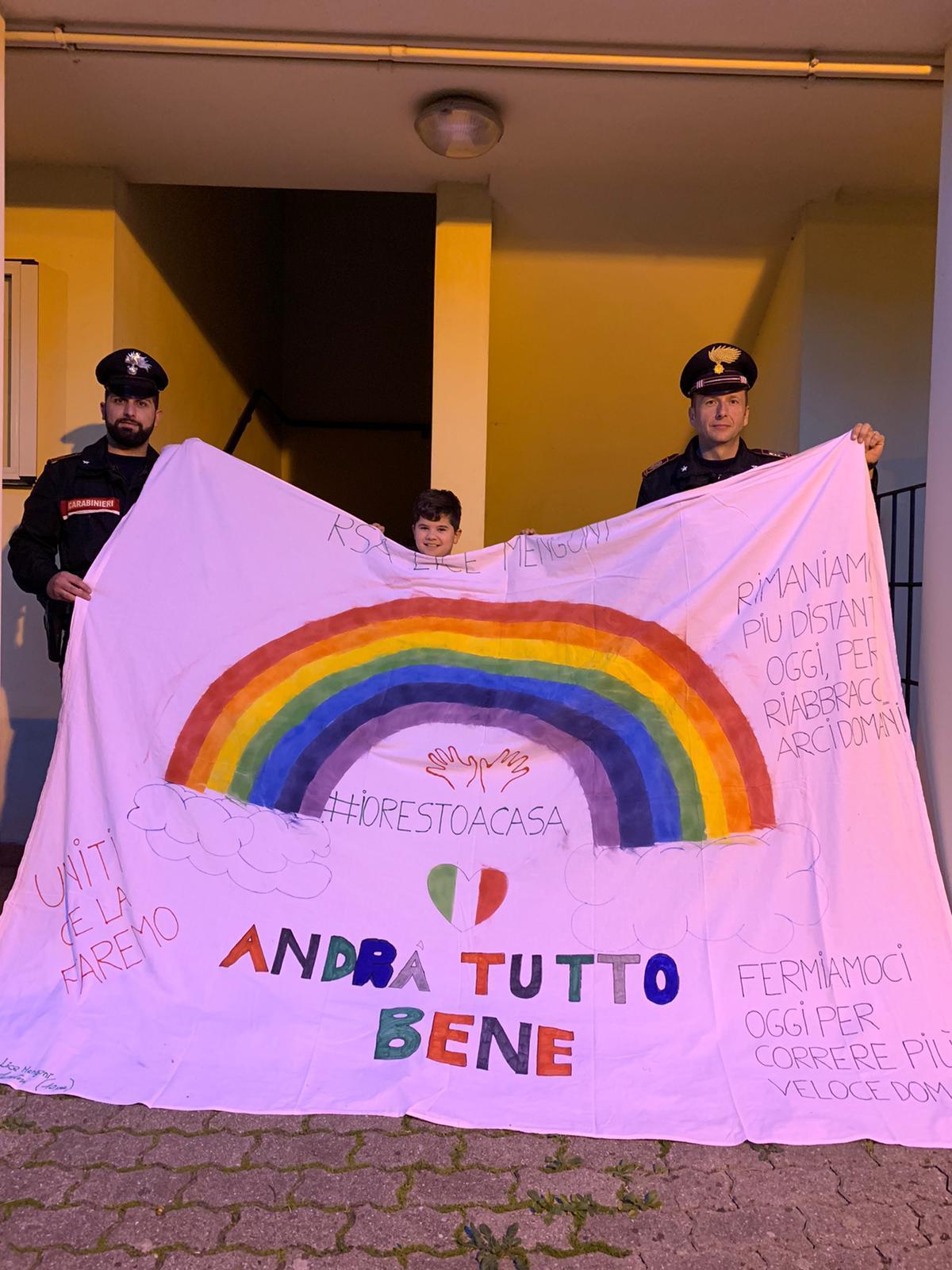I carabinieri insieme al bambino con lo striscione