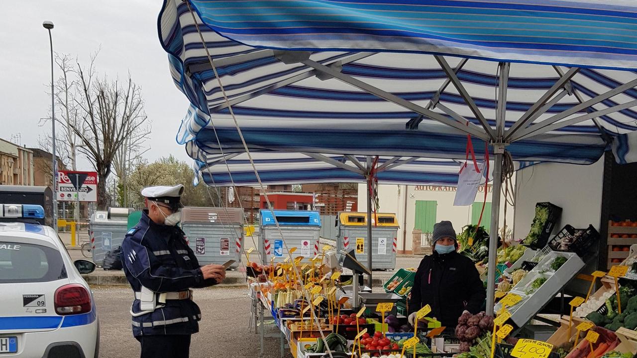 Un agente della polizia locale mentre multa una bancarella