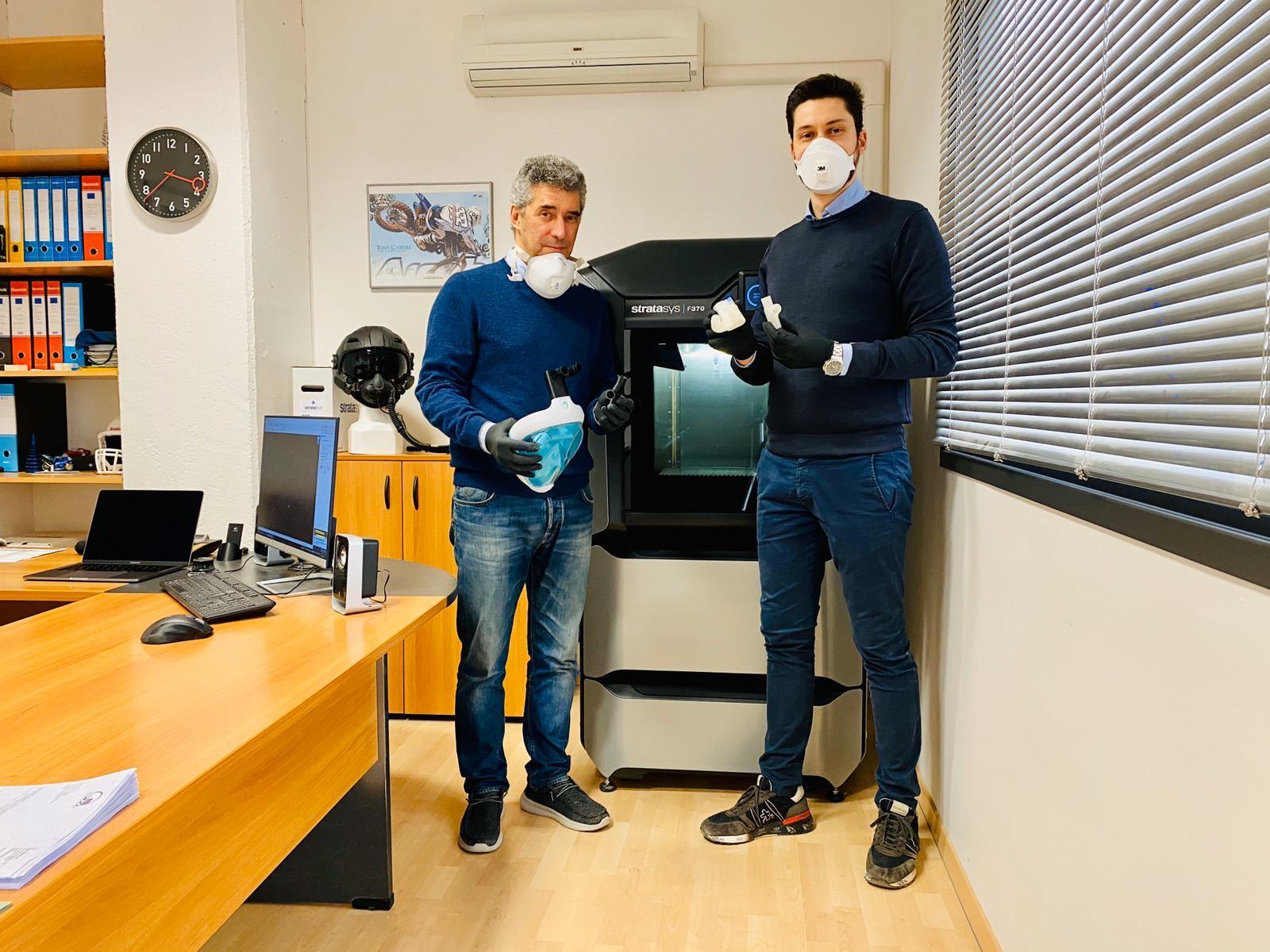 Da sinistra Luca e Matteo Occhipinti di fronte alla stampante 3D con maschera e valvole in mano