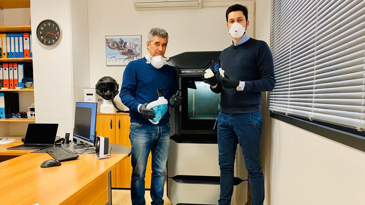 Da sinistra Luca e Matteo Occhipinti di fronte alla stampante 3D con maschera e valvole in mano