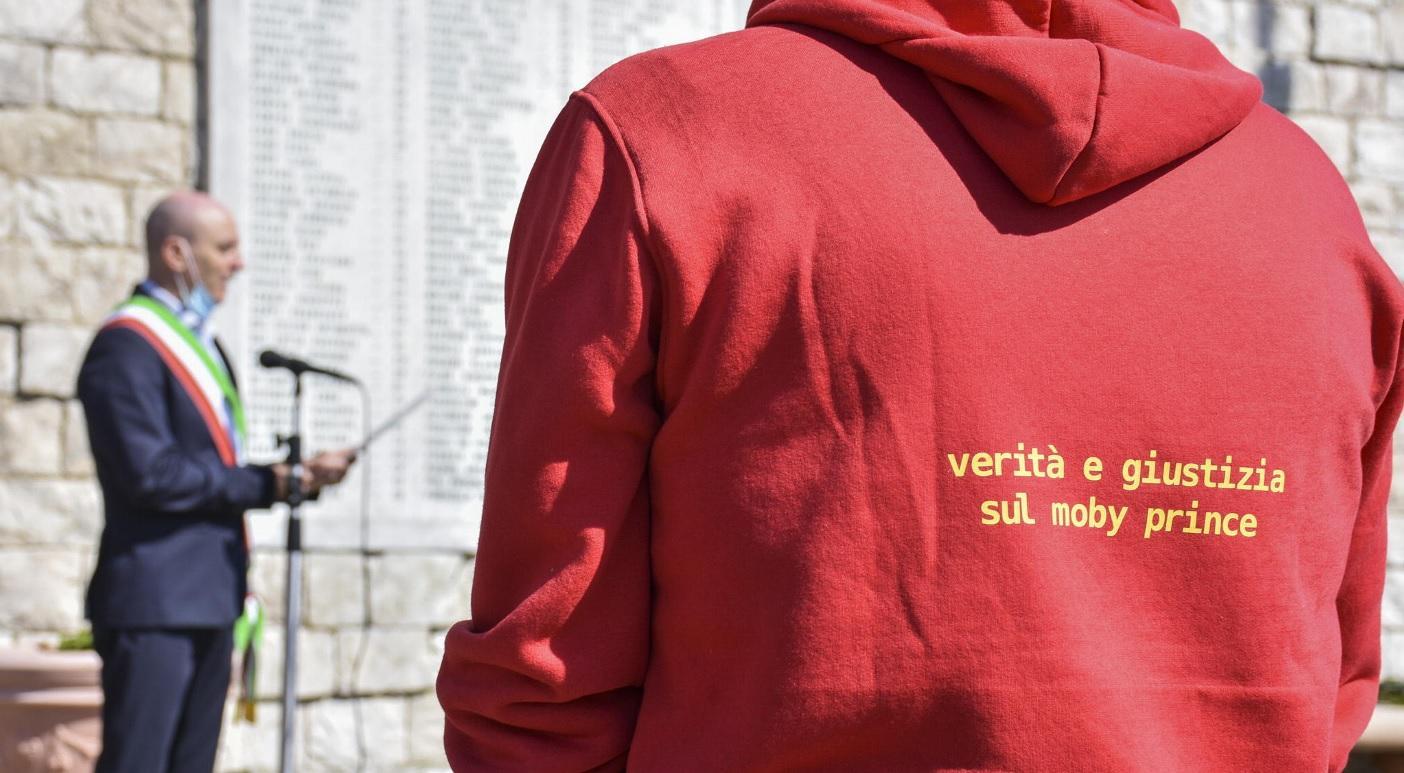 La maglietta rossa simbolo della battaglia dei familiari delle vittime del Moby mentre il sindaco Salvetti legge i nomi dei 140 morti