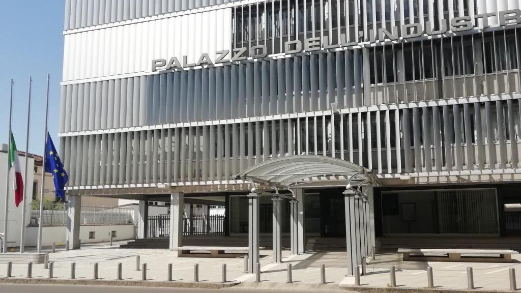 Bandiere a mezz'asta davanti alla sede di Confindustria a Prato