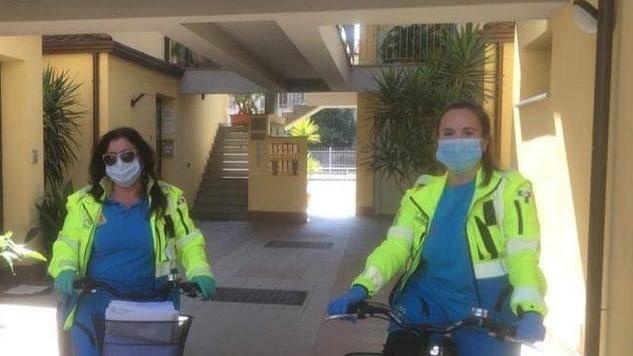 Volontarie consegnano le protezioni in bicicletta