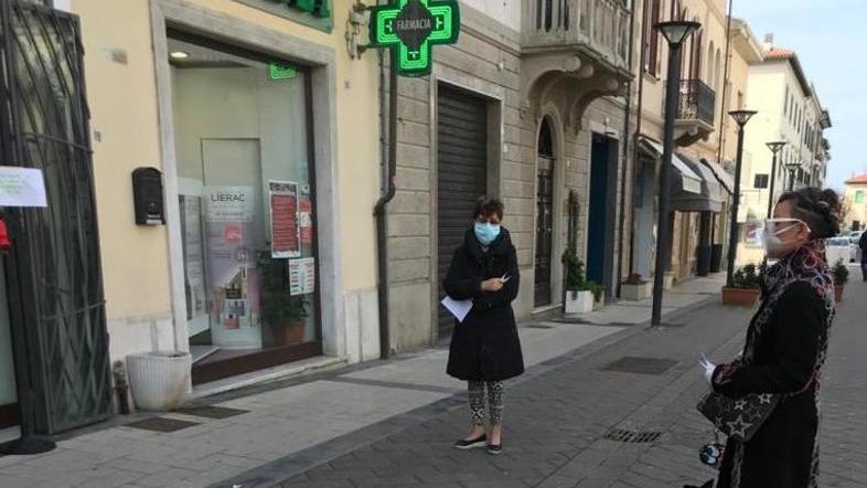 Persone in fila di fronte ad una farmacia di Cecina