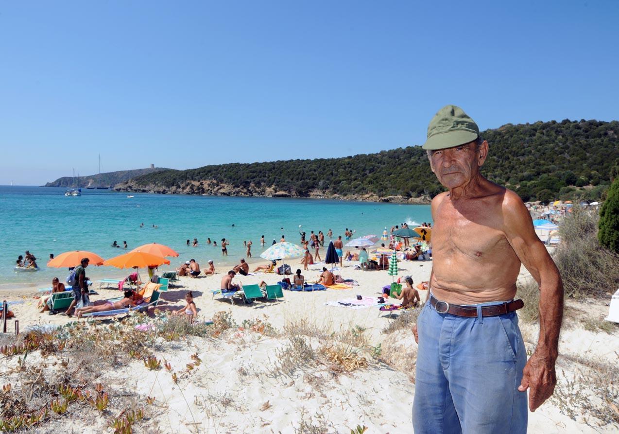 Ovidio Marras, alle sue spalle la spiaggia di Tuerredda molto affollata d'estate