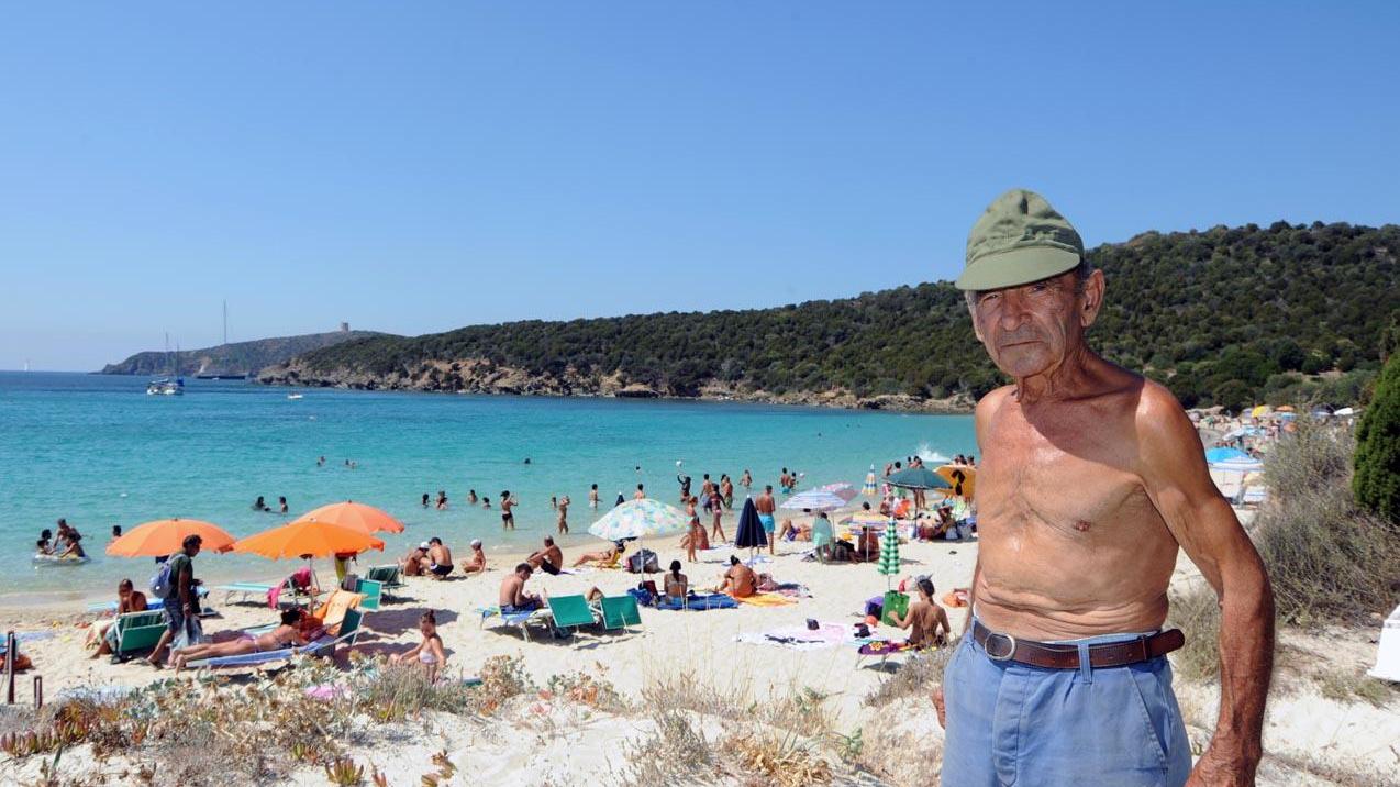 Ovidio Marras, alle sue spalle la spiaggia di Tuerredda molto affollata d'estate