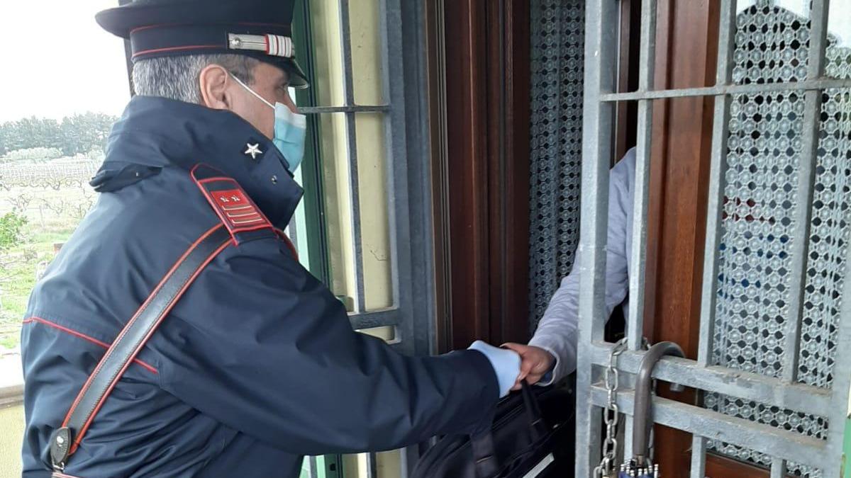 Il luogotenente carica speciale Massimiliano Meliota mentre consegna la borsa col computer all’alunno