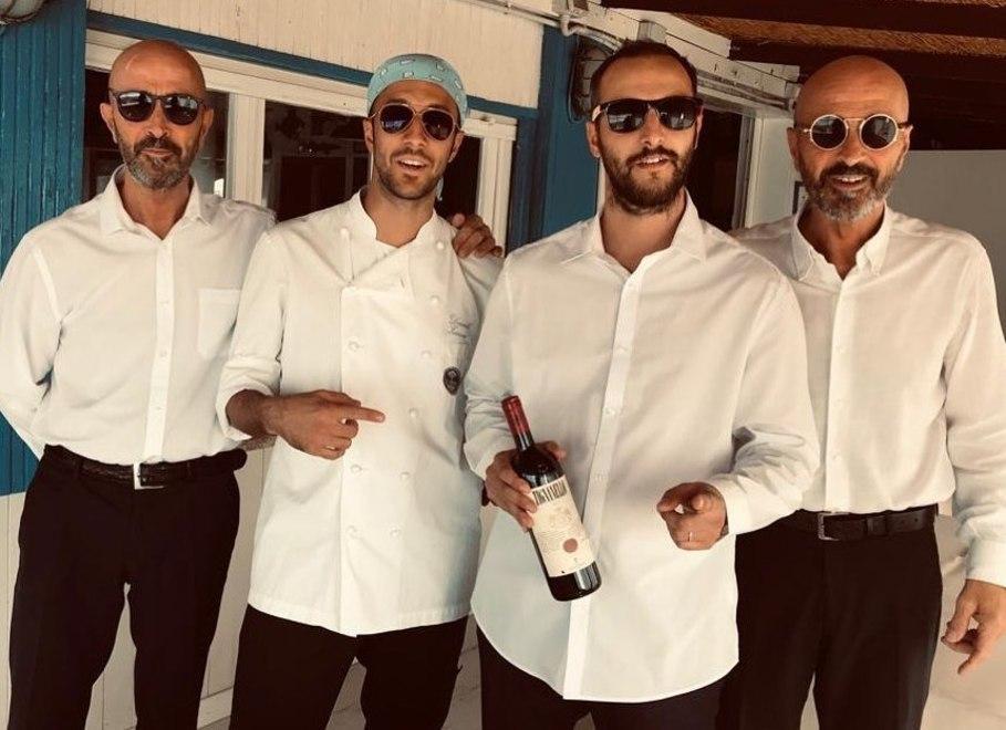 I fratelli Andrea e Daniele Zazzeri, al centro, posano insieme ai due storici camerieri del ristorante, Giovanni e Roberto Vanni